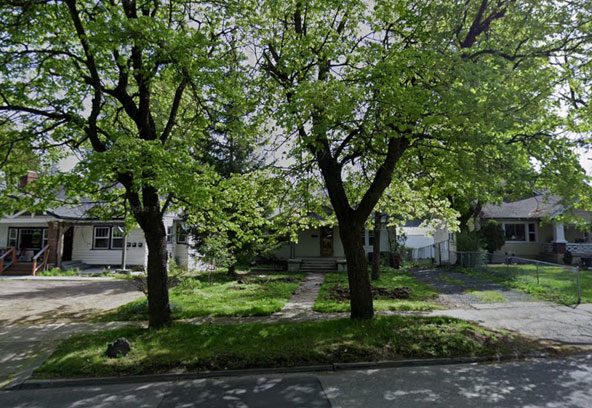 Single family homes with lawns and mature trees on a Spokane residential street